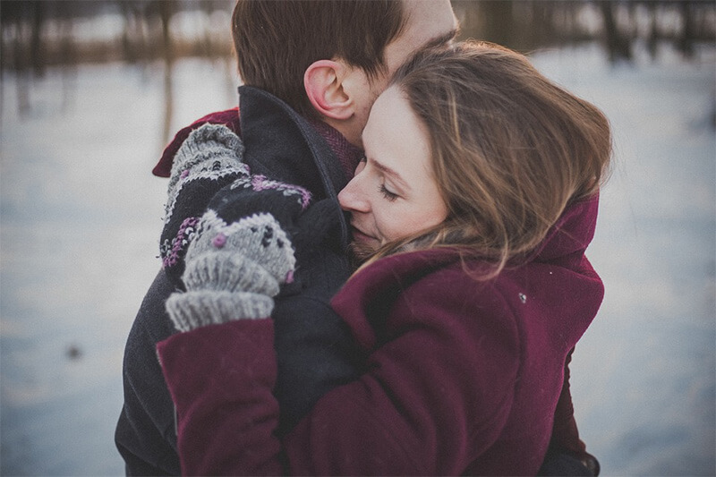 冬天，一个男人在外面拥抱一个女人。